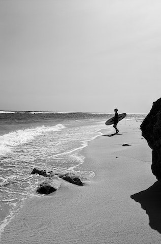 Surfer with a surfboard geting in the water